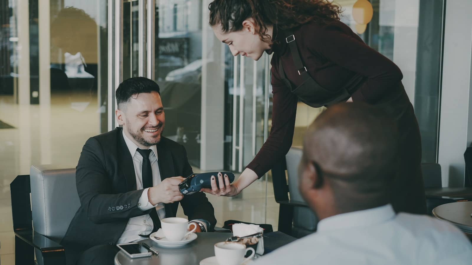 A small business owner taking a card payment at the counter